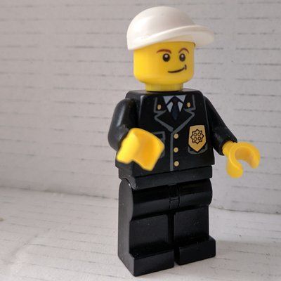 Minifiguur Policeman, Black Suit with Badge, White Cap uit set 7279