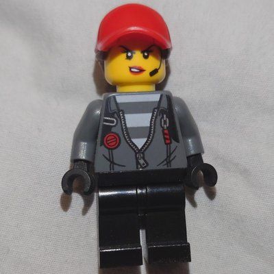 Minifigura Criminal, Woman, Open Dark Bluish Gray Jacket with Zipper over Prison Shirt, Red Cap with Hair del set 60244