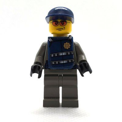 Minifigura Security Guard, Dark Gray Shirt with Badge, Dark Blue Cap, Dark Blue Vest, Orange Sunglasses del set 7033
